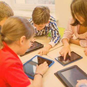 Élèves utilisant des tablettes autour d'une table