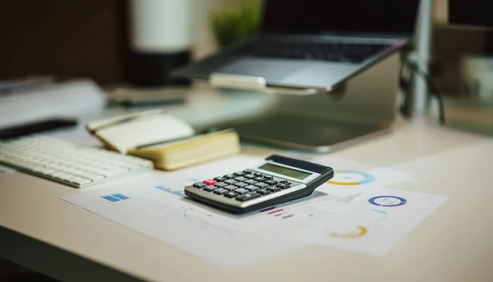 Calculatrice et ordinateur portable sur un bureau