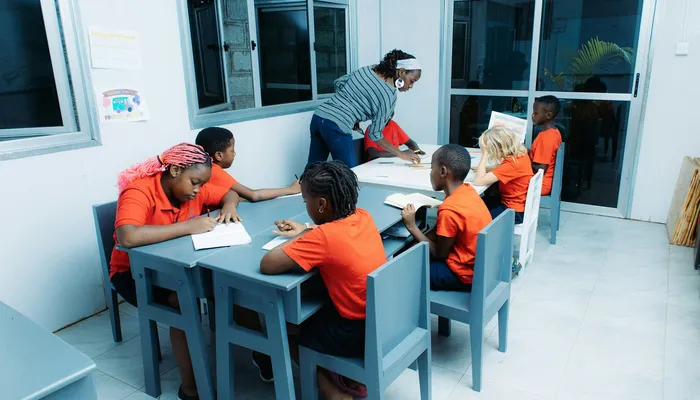 Enseignant aidant des élèves autour d'une table